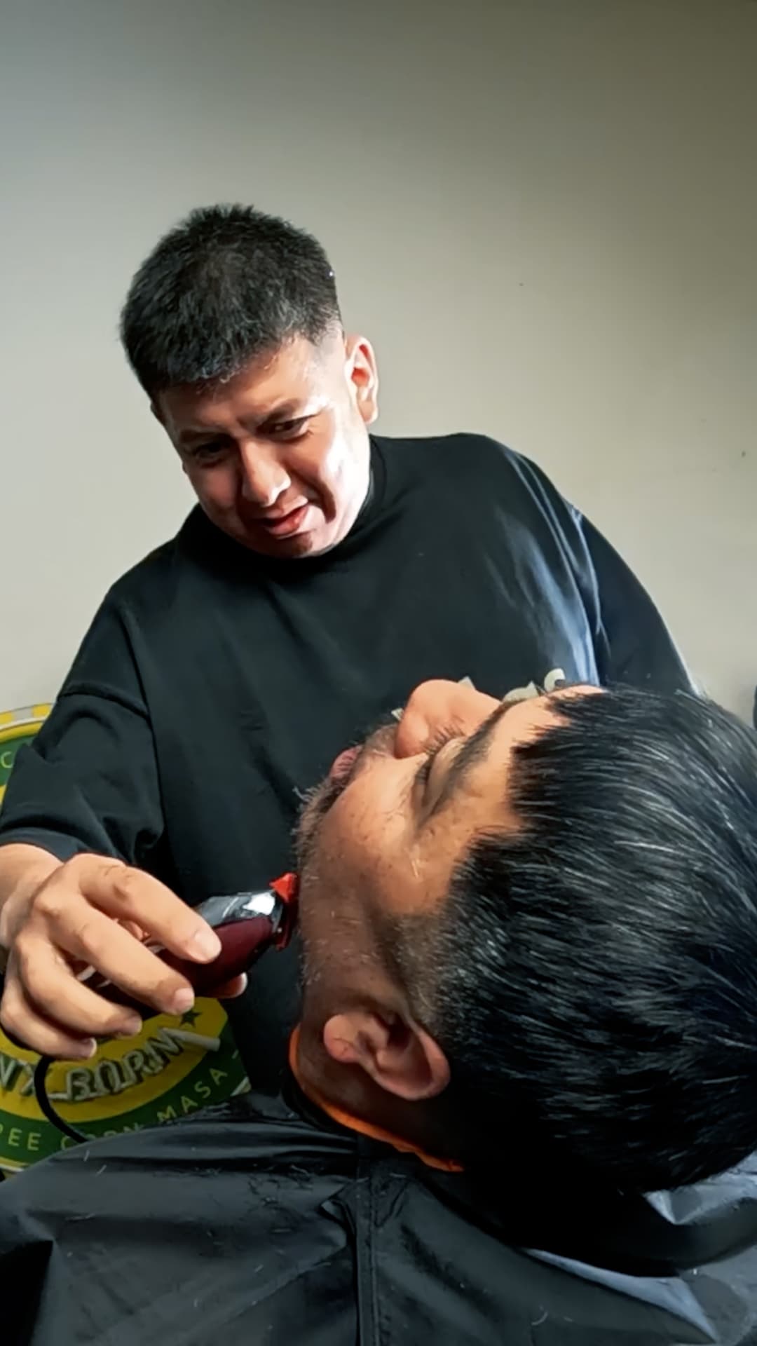 Isrrael Veliz shaping a client’s beard in the barber chair